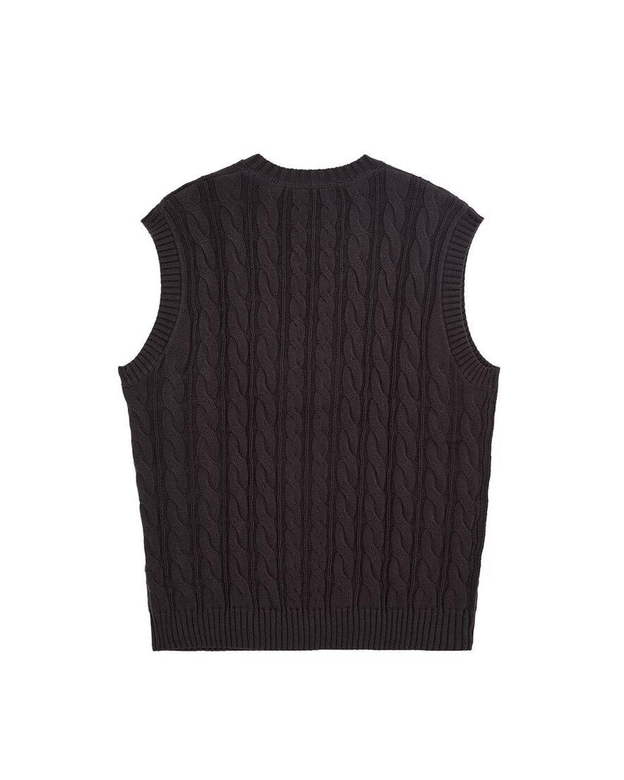 Back of a dark grey knit vest featuring vertical cable knit patterns and ribbed trim.