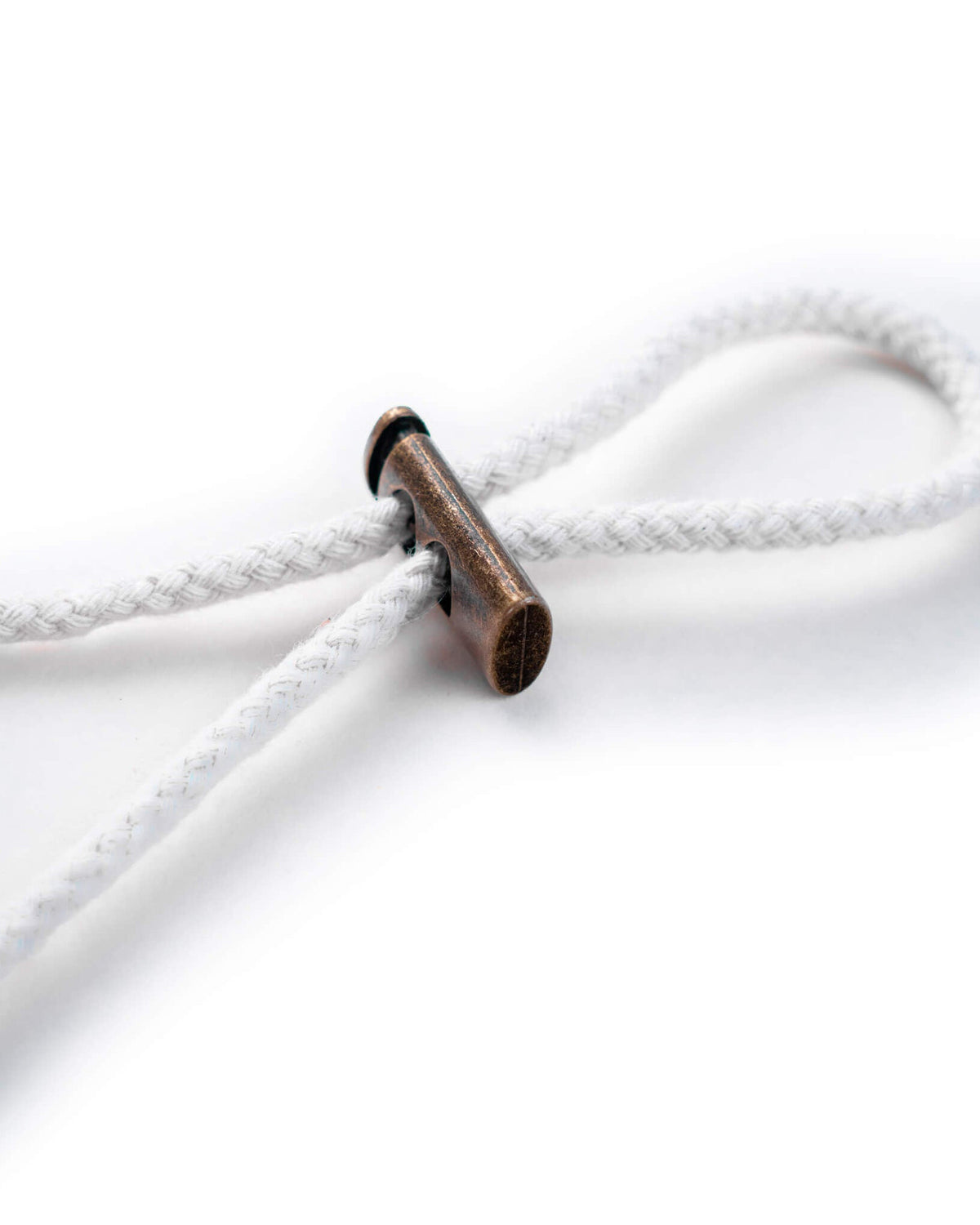 Detail of the white boonie chin strap featuring a metallic bronze toggle cinched on the cord.
