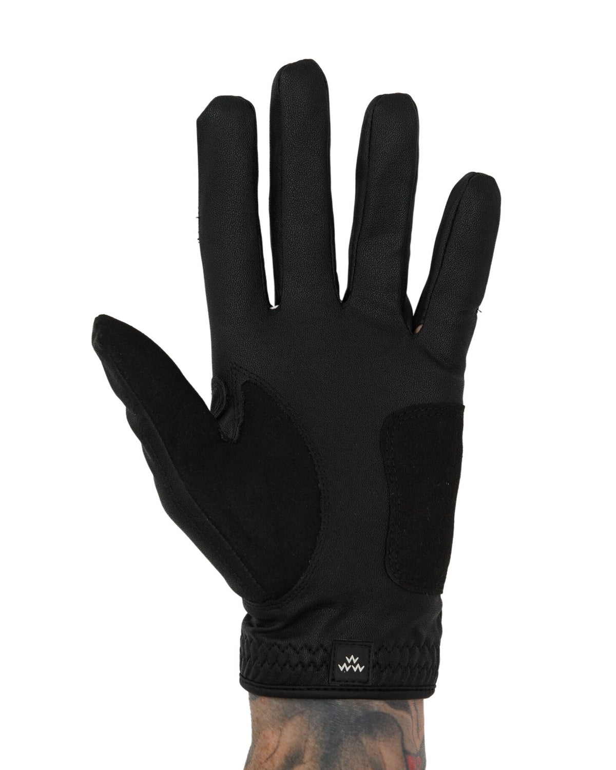 Front of a black golf glove featuring a suede palm patch and a small white script logo on the cuff.