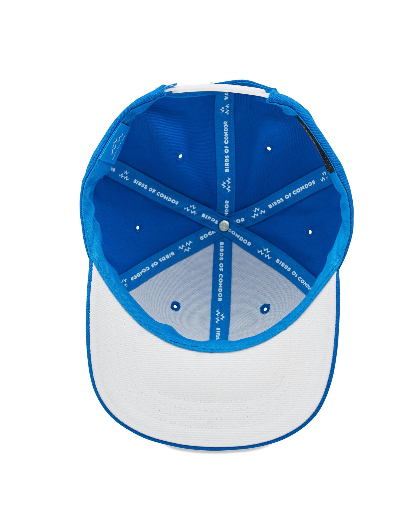 Inside view of an electric blue snapback cap showing white interior lining and branded seam taping.