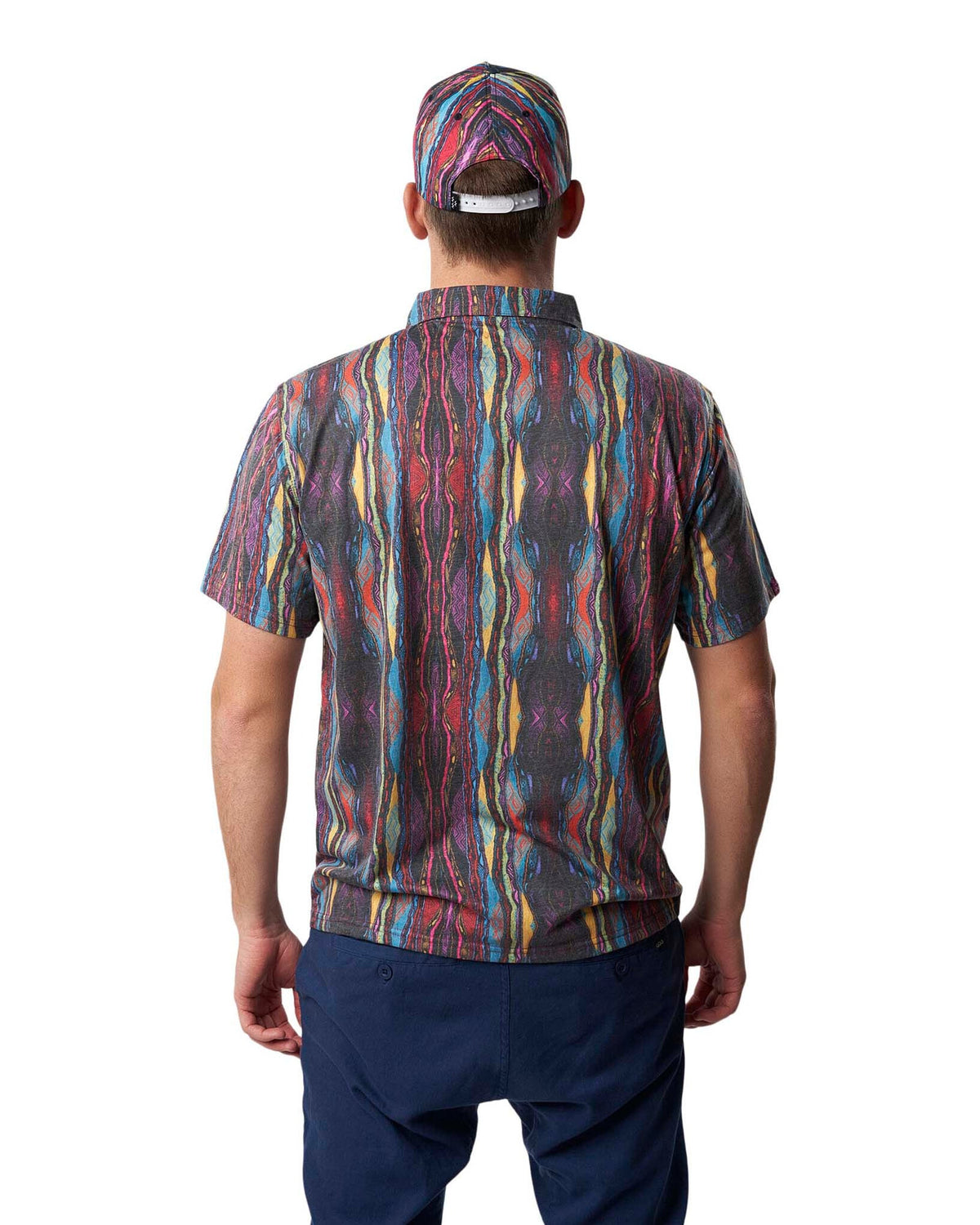 A man wearing a Coogi print cap and matching short-sleeve polo shirt from behind.