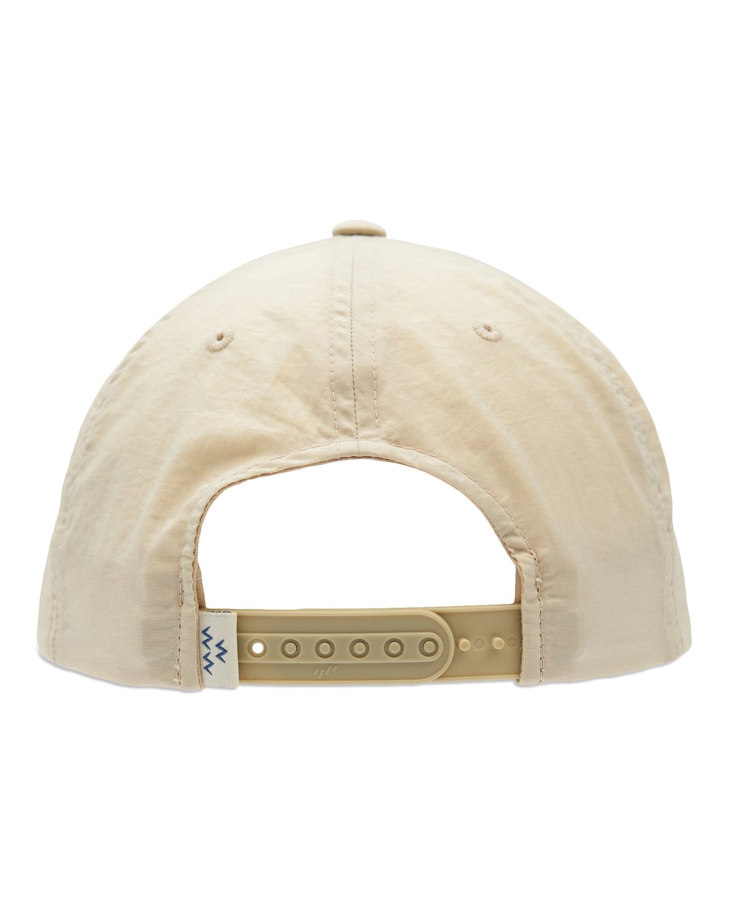 Back of a tan snapback cap with an adjustable plastic strap and a small tag beside the closure.