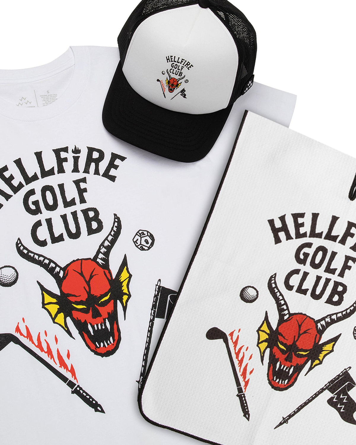 A white golf ball marker with a Hellfire Club logo, shown alongside a matching shirt, hat, and towel.
