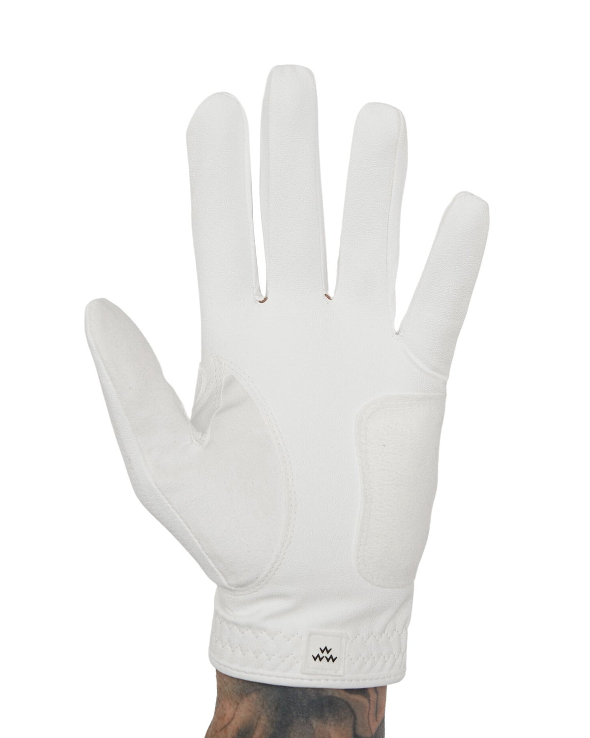 Front of a white golf glove with a suede palm patch and a small dark bird motif on the cuff.