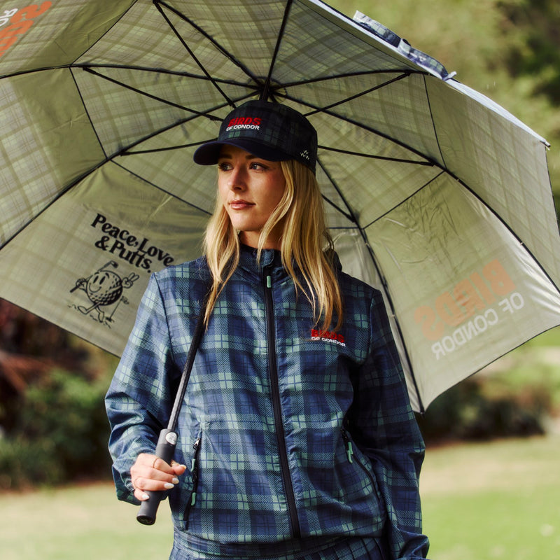 Woman holding a large Birds of Condor umbrella with a scenic background on a golf course