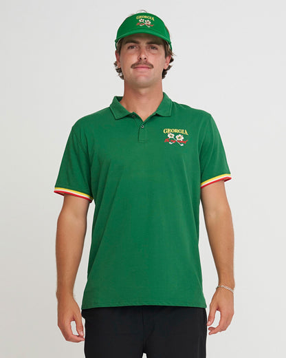 Man wearing a Birds of Condor green polo shirt with a Georgia logo and a matching Visor on a light gray background