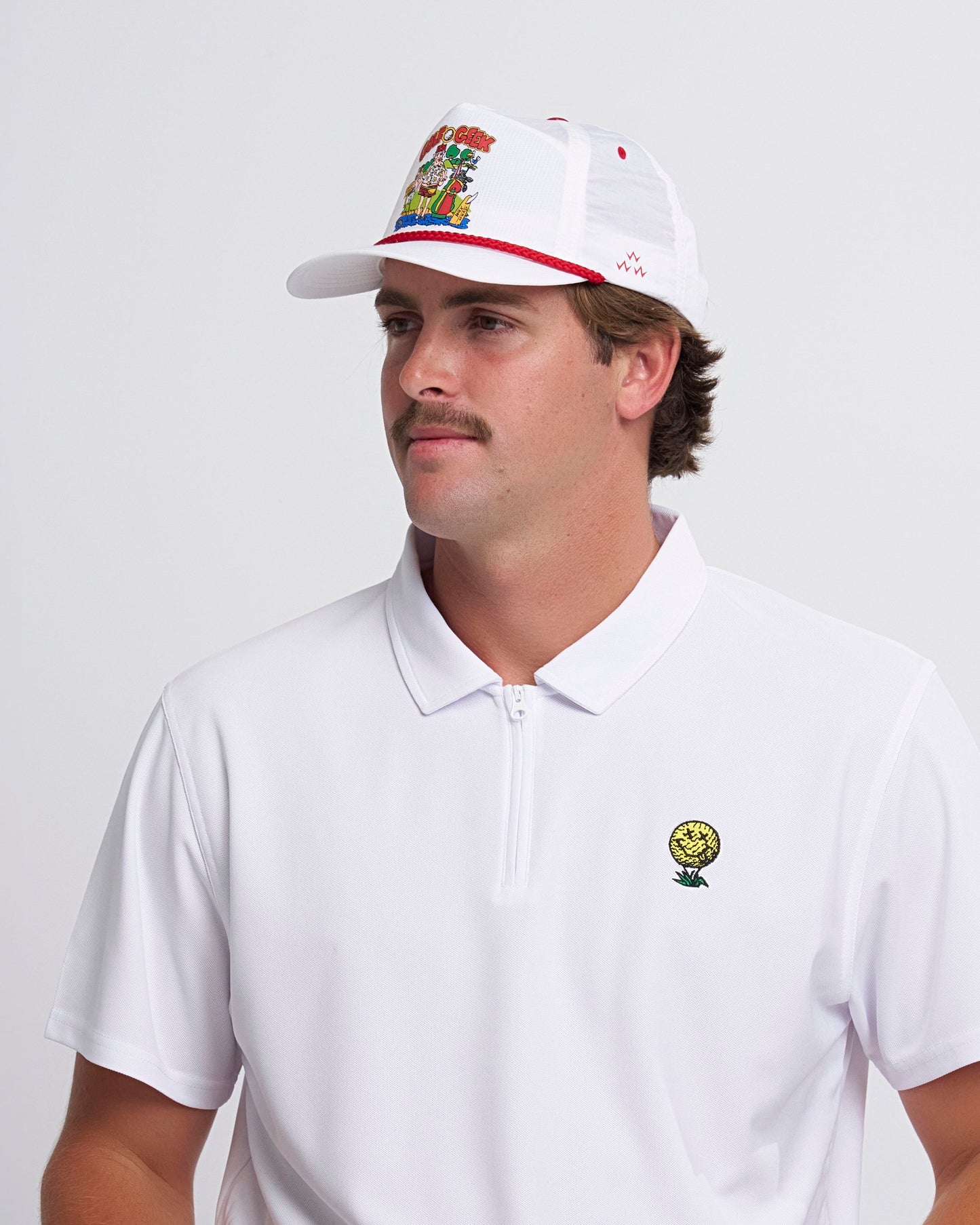 A man wearing a white snapback hat with a colorful graphic logo and red brim trim.