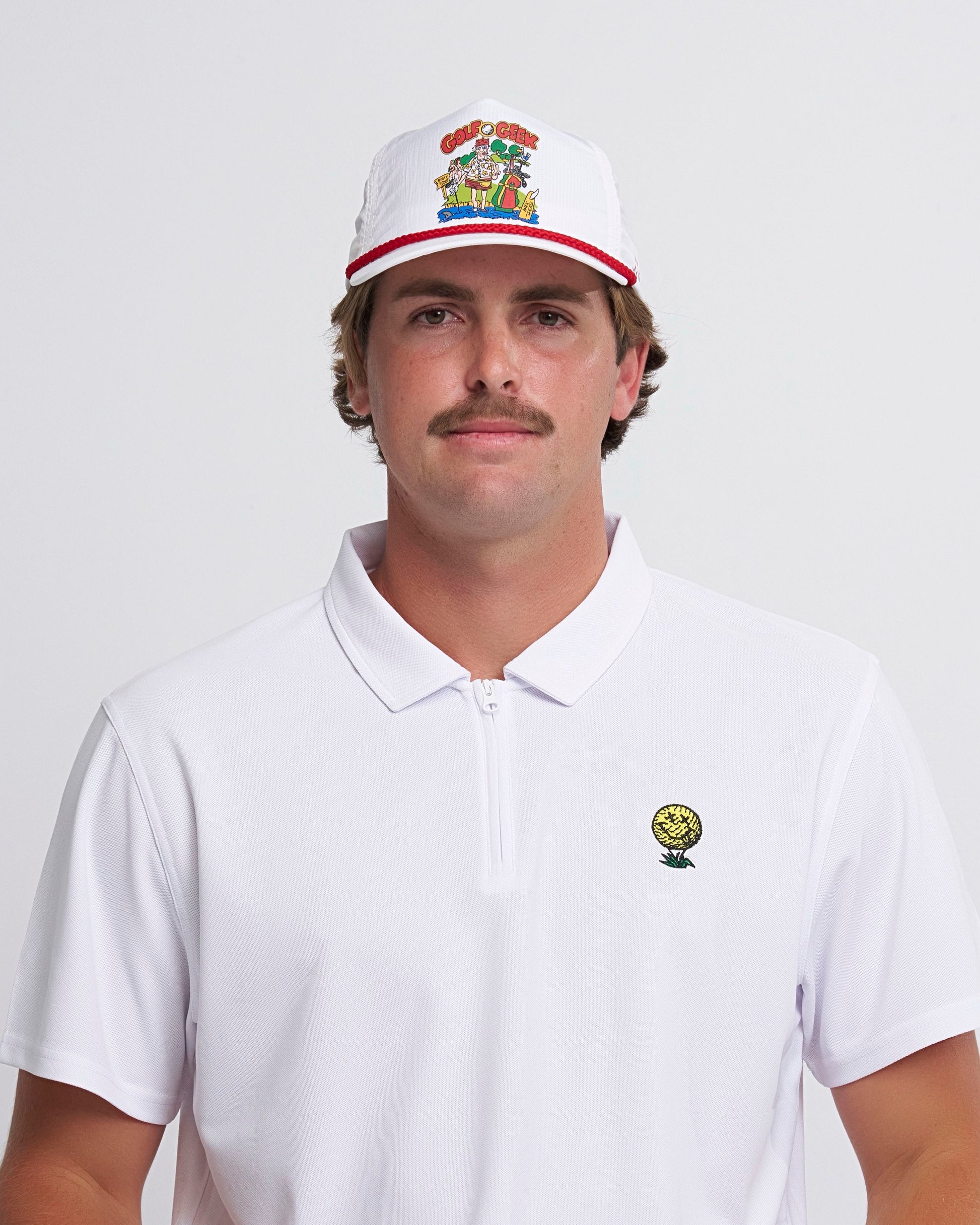A man wearing a white snapback headwear featuring a cartoon logo above a red brim trim.