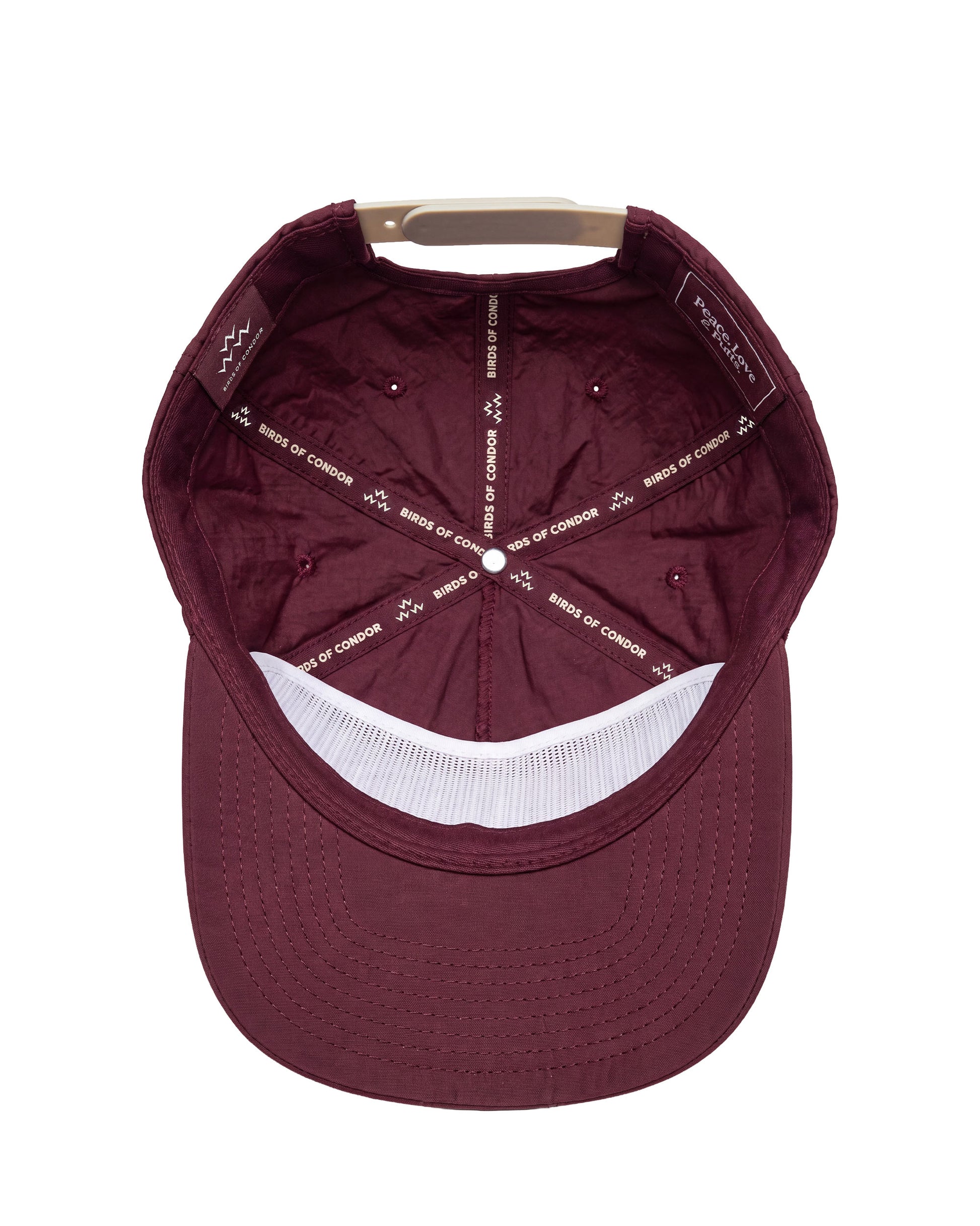 A top-down view of a maroon baseball cap with a white mesh band on the brim and white printed text on the interior panels.