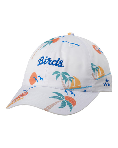 A white baseball cap featuring a colorful tropical beach print with palm trees, sunsets, waves, and the word 'Birds' embroidered in blue on the front.