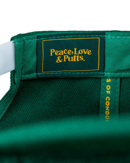 Detail of a green snapback showing a dark green interior label with yellow Peace, Love and Putts text.