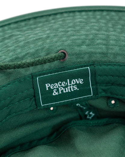 Detail of a green boonie hat featuring an interior woven label with white Peace, Love & Putts. text.