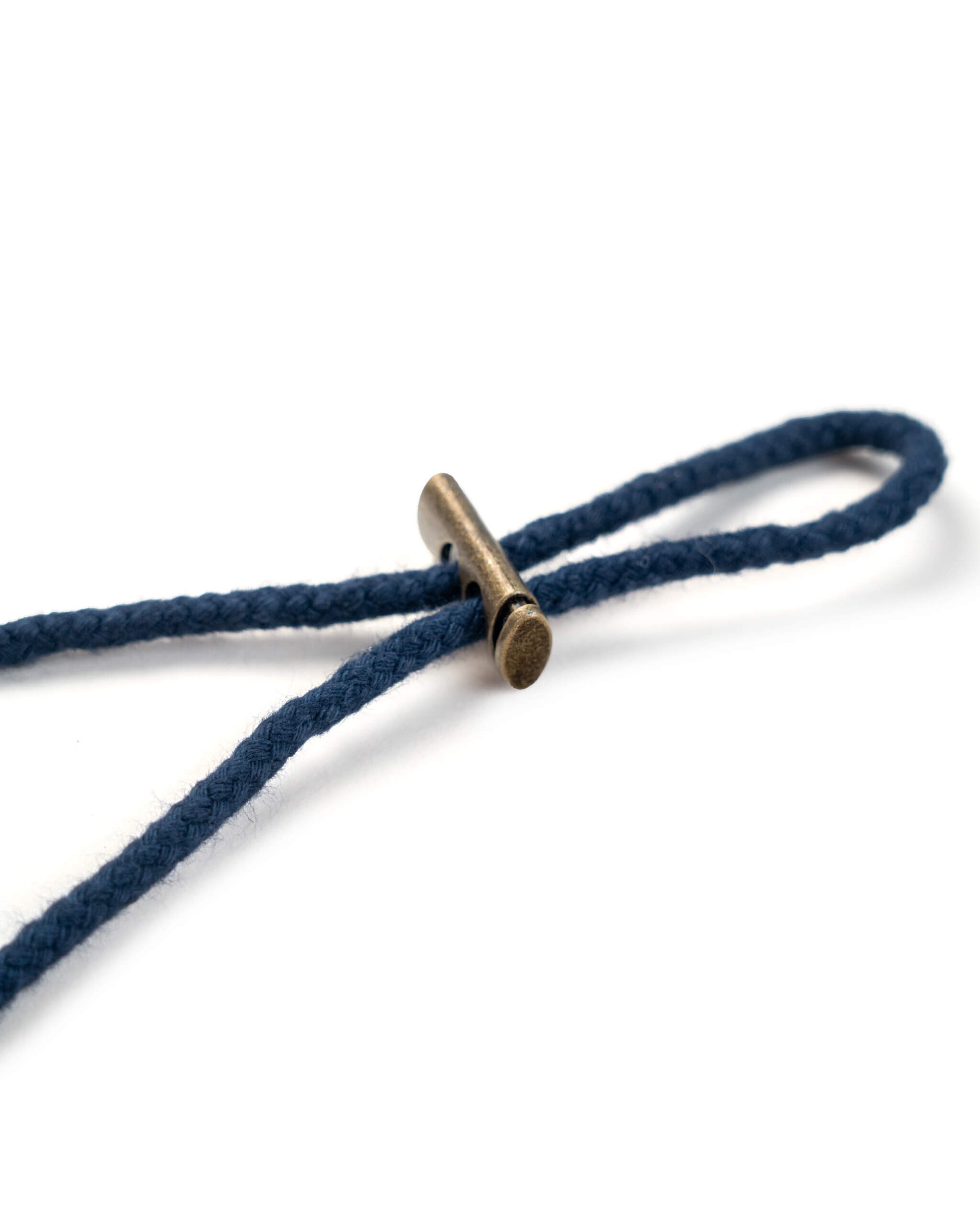 Detail of the navy boonie chin strap secured with a rectangular brass-toned metal toggle fastener.