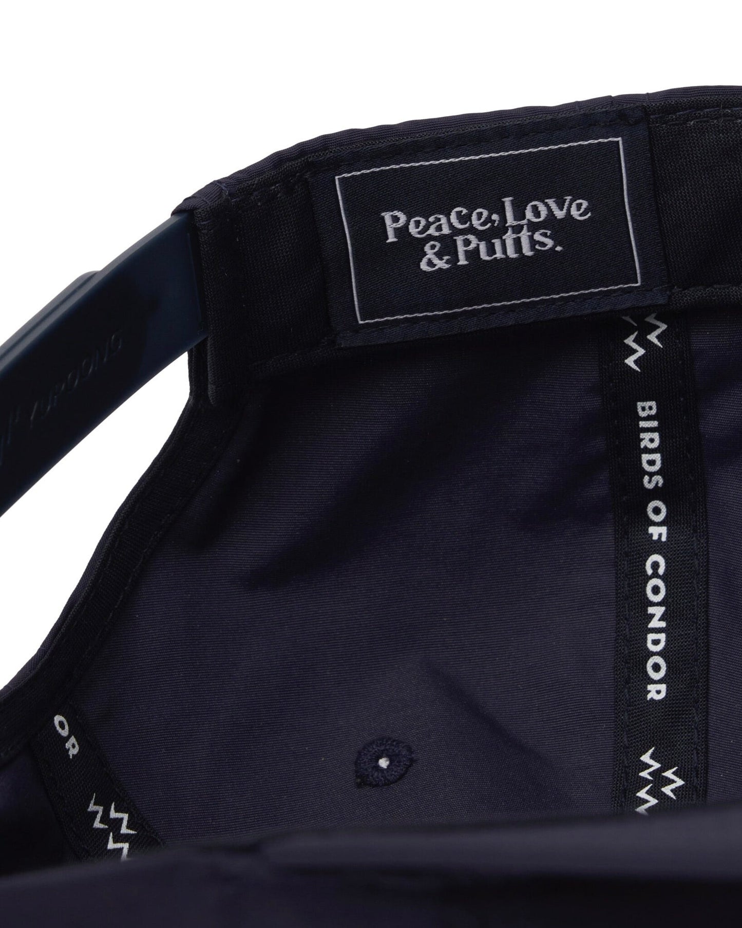 Detail of the interior lining of a navy snapback showing a woven brand label and branded seams.