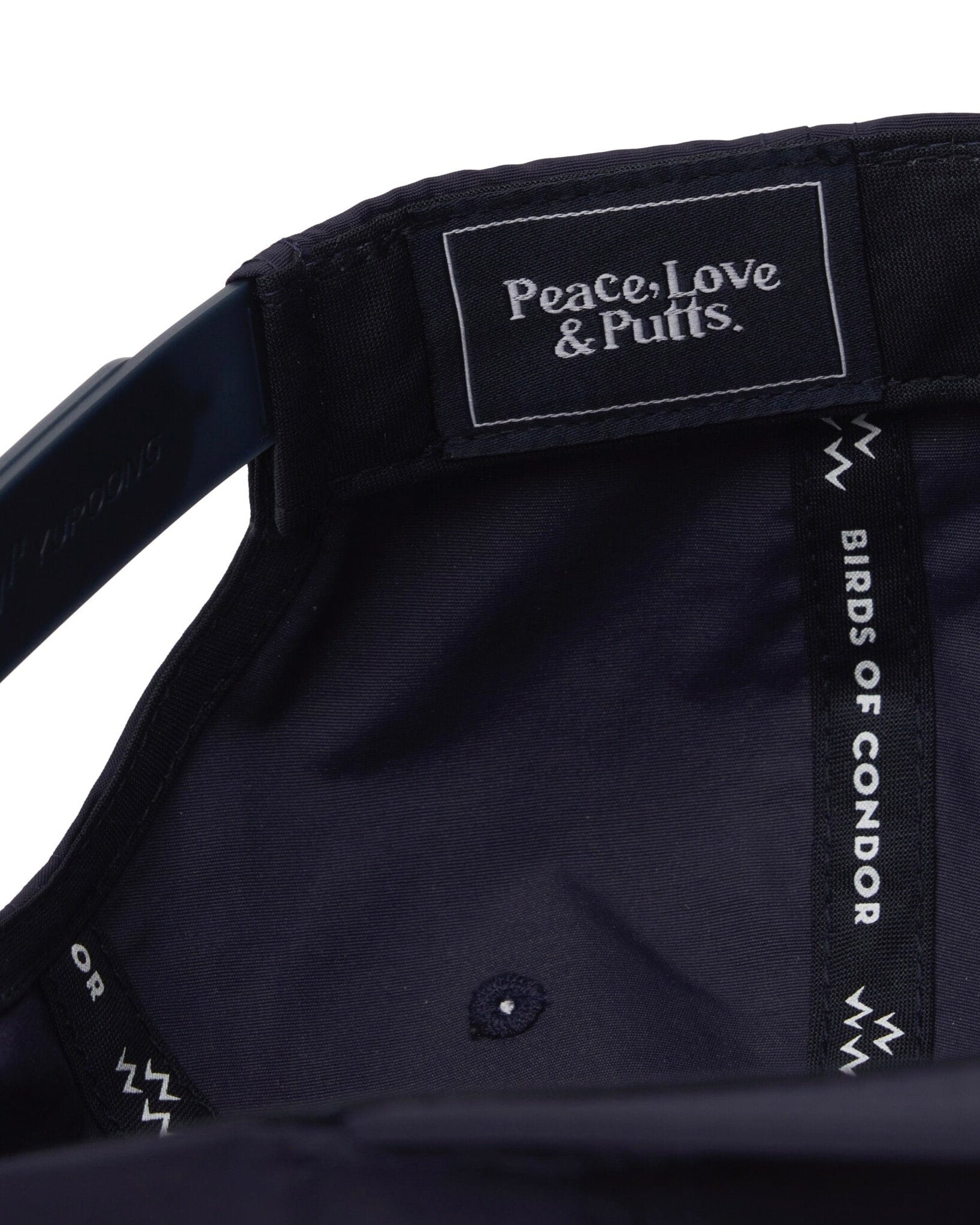 Detail of the interior lining of a navy snapback showing a woven brand label and branded seams.