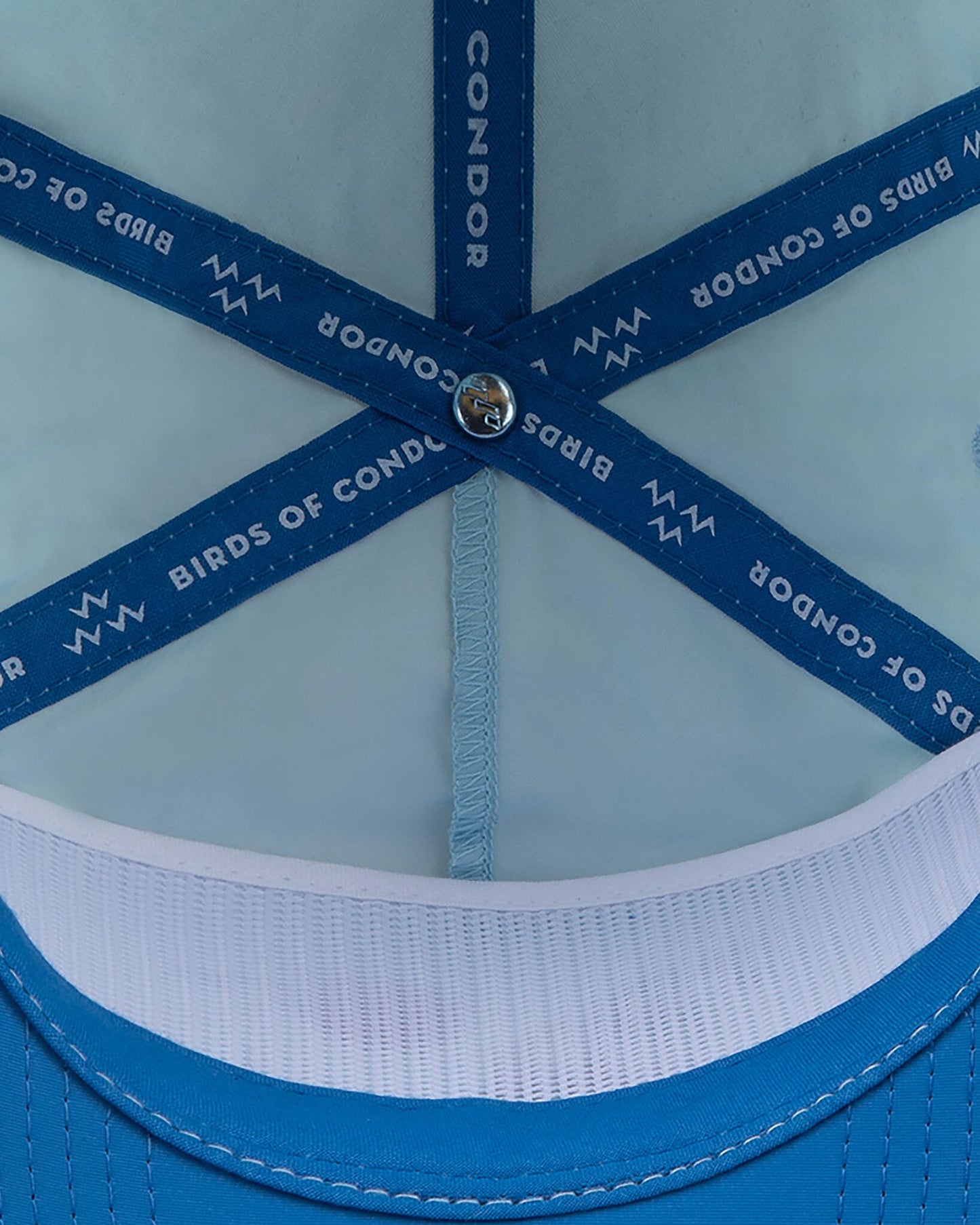 Detail of the interior of a sky blue cap, featuring blue branded inner seam tapes.