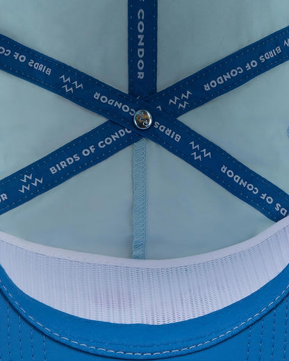 Detail of the interior of a sky blue cap, featuring blue branded inner seam tapes.